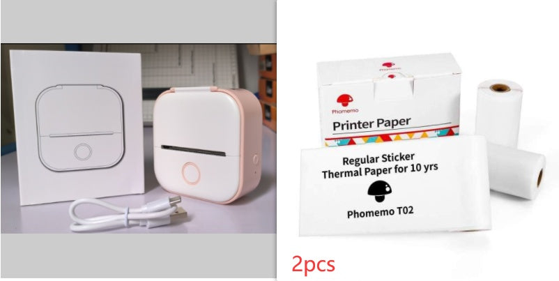 Portable mini thermal label printer with accessories including printer paper and charging cable.